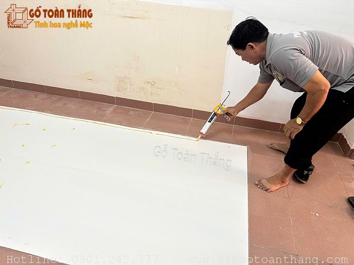 Bôi keo vào mặt sau tấm PVC Bôi keo vào mặt sau tấm PVC